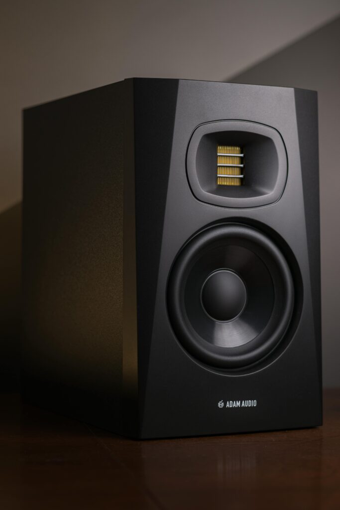 Close-up of a black studio monitor speaker highlighting its sleek design and sound technology.